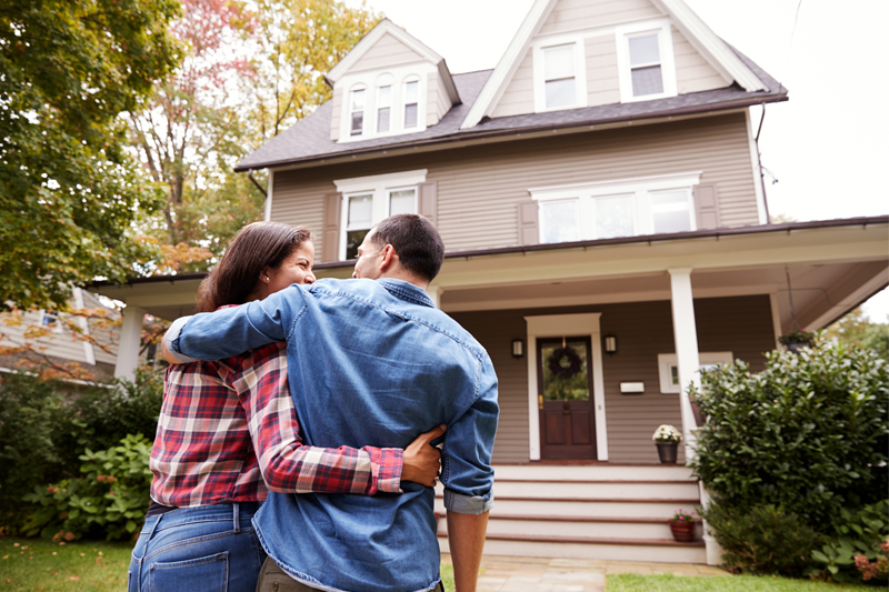 Couple in front of a home