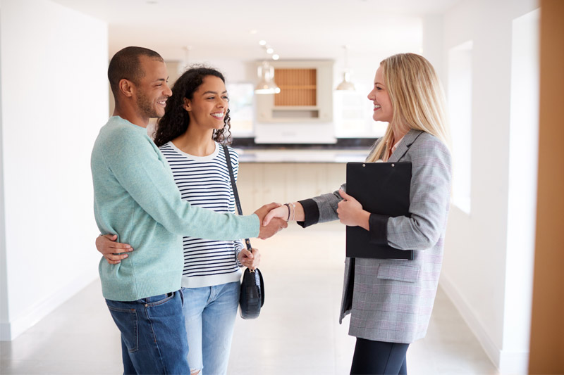 Couple shaking hands with a realtor